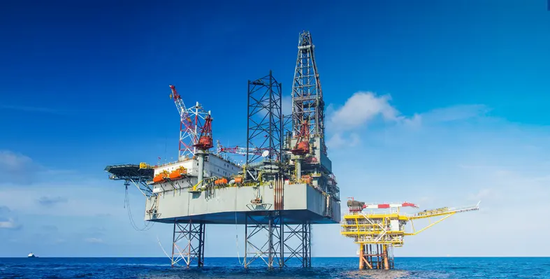 The webinar explored how AI surveillance applications can enhance operational efficiency and improve standards in onshore and offshore operations. (Image source: Adobe Stock) Oil rig in the sea with smaller rig in the background against blue sky